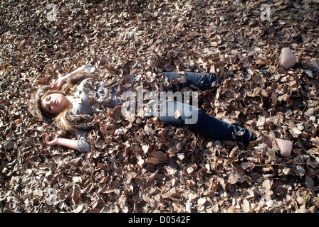 Frau begraben in Eiche Blätter Stockfoto