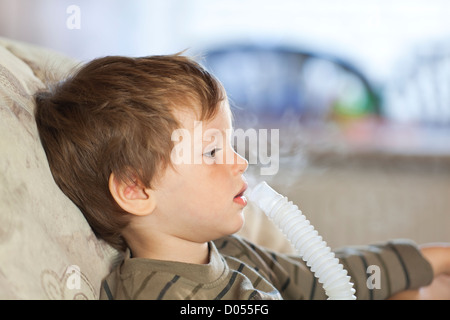 Kleiner Junge mit Zerstäuber inhalieren Medizin, Nahaufnahme Seitenansicht Stockfoto