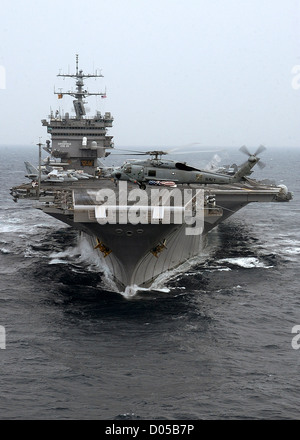 Ein SH-60F Seahawk Pässe der Bug der USS Enterprise 7. Juli 2004 als das Schiff durch das Wasser des Atlantischen Ozeans folgende dampft ein Hafen besuchen nach Portsmouth, England. Stockfoto