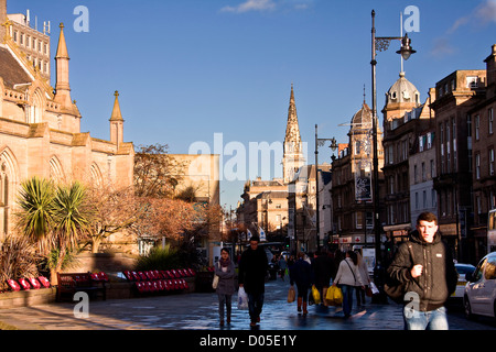 Passanten, die Reihen von Mohn Kränze entlang der Kirchturm Kirchenmauer an einem sonnigen Tag in der Innenstadt von Dundee, UK Stockfoto