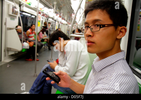 Shanghai China, chinesische Metro, U-Bahn, Zug, Zug, Fahrer, asiatischer Mann Männer Erwachsene Männer, grüne Linie 2, mit dem Verwenden, Smartphone-Handys, überprüfen Stockfoto