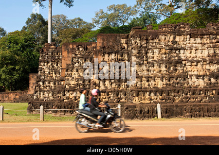 Motorradfahrer, vorbei an TheTerrace von Leper King, Angkor Thom, Siem Reap, Kambodscha Stockfoto