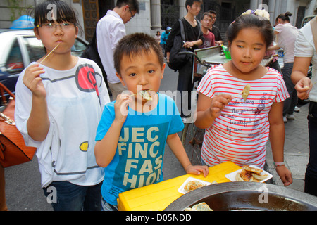Shanghai China, Huangpu District, Dianchi Road, Asian Boy Boys, Male Kid Kids child children Youngster, girl girls, weiblich, Knödel, Essen, Essen, Straße, Vend Stockfoto