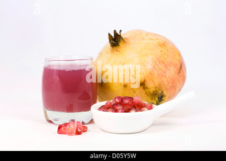 Punica Granatum. Granatapfel-Saft und Obst vor einem weißen Hintergrund. Stockfoto