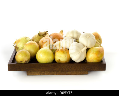 Zwiebeln und Knoblauch auf einem Holzbrett vor einem weißen Hintergrund präsentiert Stockfoto