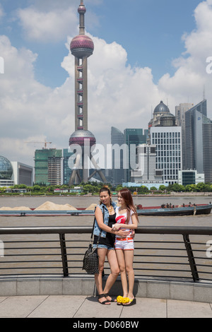 Junge Frauen posieren für ein Foto mit der Skyline von Lujiazui Pudong Shanghai, China Stockfoto