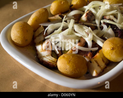 Typisch portugiesisches Gericht Polvo À Lagareiro - Oktopus gekocht mit Kartoffeln und beträufelt mit Olivenöl, Knoblauch und Zwiebeln Stockfoto