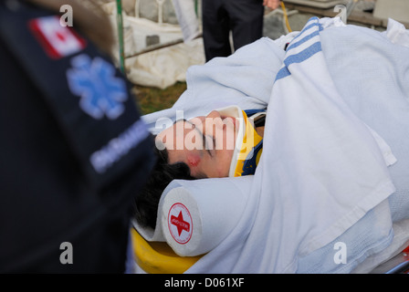 Mann auf einer Trage in einer Halskrause nach einer Verletzung, Stockfoto