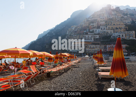 Positano Strand-Szene mit Liegestühlen und Sonnenschirmen, Kampanien, Italien Stockfoto