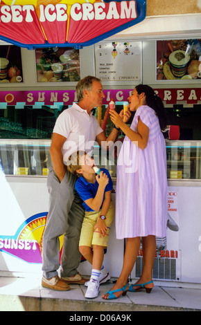 Ein Paar mit einer schwangeren Frau und einem Jungen, die Eiscreme in einem Friseursalon in Frankreich, Europa essen Stockfoto