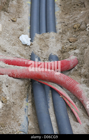 Detail einer Ausgrabung auf einer Baustelle für die Verlegung von Gasleitungen und Stromleitungen und Wasserleitungen Stockfoto