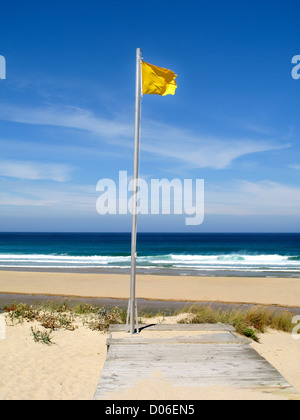 Wunderschöne Landschaft mit Wellen brechen sich am Meer und gelbe Flagge Stockfoto
