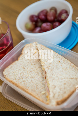 Sandwiches und einen Topf mit Trauben für das Mittagessen in einer Sandwich-Box. Stockfoto