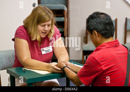 Weibliche Freiwillige bietet spirituelle Unterstützung und Gebet für Patienten in Mission lächelt mobile Zahnklinik in Temple Terrace, FL Stockfoto