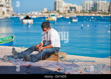 Maltesische Fischer seine Netze reparieren Stockfoto