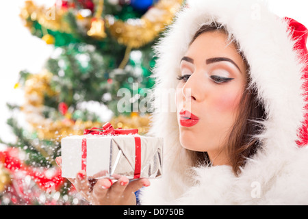 Schöne Santa Mädchen Schneetreiben aus Silber Weihnachts-Geschenk-Box in der Hand. Stockfoto