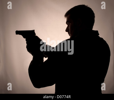 Silhouette eines Mannes mit einer Pistole Stockfoto