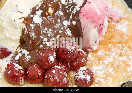 köstliches Dessert mit Waffeln, Eis und Kirschen in Nahaufnahme Stockfoto
