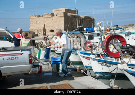 Mittelalterliche Festung von Pafos mit Blick auf die Fischerboote auf Paphos Hafen südlichen Zypern Fischer seinen Fang von Touristen beobachtet werden geladen Stockfoto