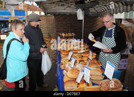 Handwerkliche Bäcker Brot zu Kunden in Chichester Open-Air-Markt England Großbritannien Stockfoto