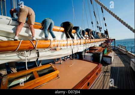 Besatzungsmitglieder an Bord der historischen Schoner 'Zodiac' steckte die Segel nach einem Segelboot-Rennen in Port Townsend, Washington, USA. Stockfoto