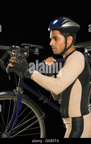 Radfahrer, die ein Fahrrad auf der Schulter tragen Stockfoto