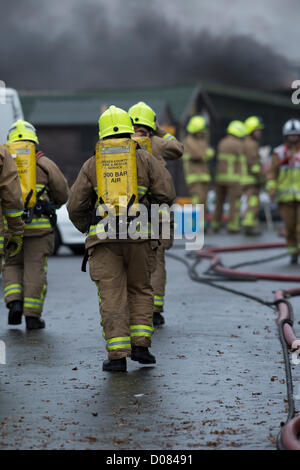 Wenig Warley, Essex, England. Ca. 05:00 heute Morgen begann ein Feuer ein gebrauchtes Speiseöl recycling-Anlage. Massiven Schaden wurde aber keine gemeldeten Verletzungen verursacht. Auf dem Höhepunkt der Blaze hatte Essex Fire and Rescue 12 Pumpen anwesend. Es war ein sehr chaotisch und gefährlich Vorfall für die Feuerwehr. Eine Gruppe von Feuerwehrleuten Atemschutzgerät tragen nähern sich die Szene. Stockfoto