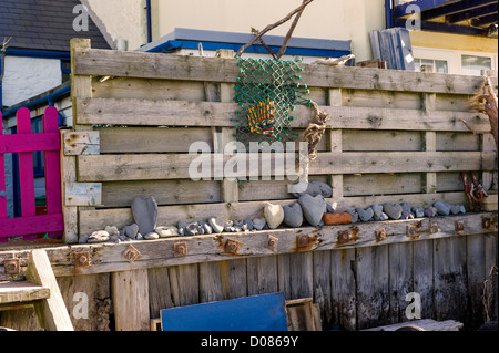 Strand Seite Bewohner zeigen ihre Strandläufer Funde auf der Gartenmauer, seltsam geformte Kiesel, bemalten Steinen, ungerade Bits von Holz Stockfoto