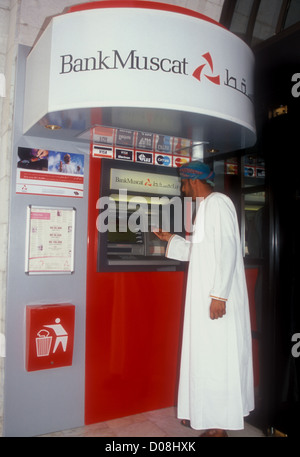 Mann, der Geld von einem Geldautomaten abzieht Muscat, Sultanat von Oman Stockfoto