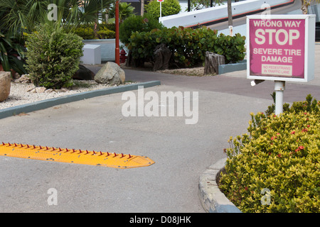 Hotel-Parkplatz-Ausfahrt mit Traffic-Spitzen und Warnschild - Stop schwere Reifenschäden Stockfoto