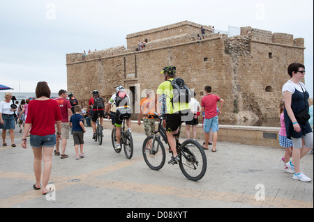 Urlauber und Radfahrer mischen sich in der Nähe der mittelalterlichen Festung von Pafos in Paphos Zypern Stockfoto