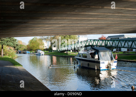 Ein kleines Boot navigiert seinen Weg unter einer Straßenbrücke nahe dem Eingang zum Schloss Marina Nottingham Kanal Stockfoto