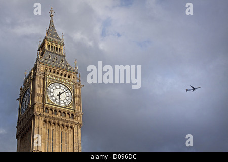 REGNERISCHEN HIMMEL ÜBER BIG BEN IM HINTERGRUND FLUGZEUG FLIEGT ÜBER LONDON BRITISCHE PARLAMENT LONDON ENGLAND GROßBRITANNIEN VEREINIGTES KÖNIGREICH Stockfoto