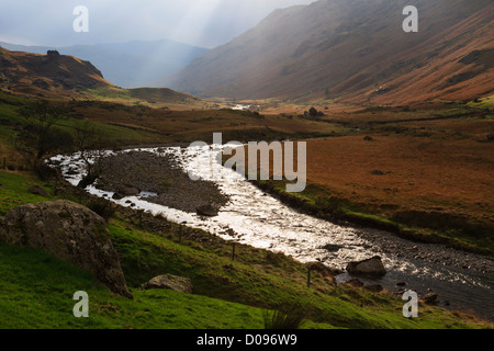 Sunburst über Langstrath Beck durchströmenden Tal im Lake District National Park Stonethwaite Borrowdale Cumbria England UK Stockfoto