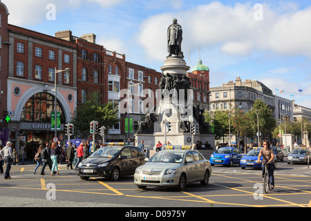 Beschäftigt Straßenszene mit Stadtverkehr vorbei Daniel O' Connell Monument auf O'Connell Street, Dublin, Süden von Irland, Eire Stockfoto