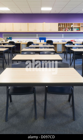 Innenraum eines Klassenzimmers in einem modernen Gymnasium mit Schreibtischen, Stühlen und Wand montiert Schränke. Stockfoto