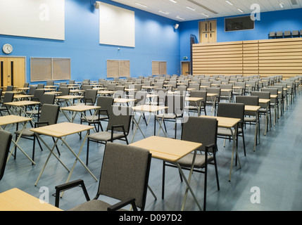 Die Haupthalle des modernen Mittelschule dargelegt für Prüfungen mit Reihen von Tischen und Stühlen. Stockfoto