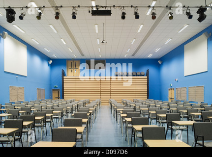 Die Haupthalle des modernen Mittelschule dargelegt für Prüfungen mit Reihen von Tischen und Stühlen. Stockfoto