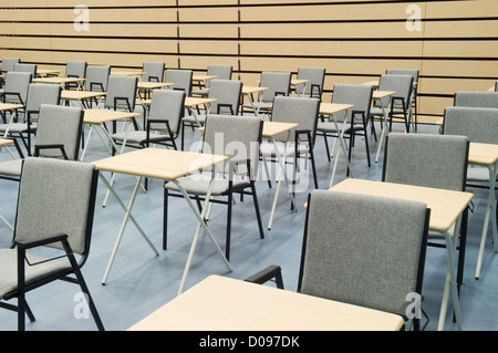 Die Haupthalle des modernen Mittelschule dargelegt für Prüfungen mit Reihen von Tischen und Stühlen. Stockfoto