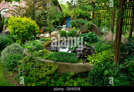 Ein "Gadage": Struktur aus Granit, die früher verwendet wurde, um die Äpfel in Apfelwein, gebaut im Becken mit Wasserpflanzen zu mahlen. Stockfoto