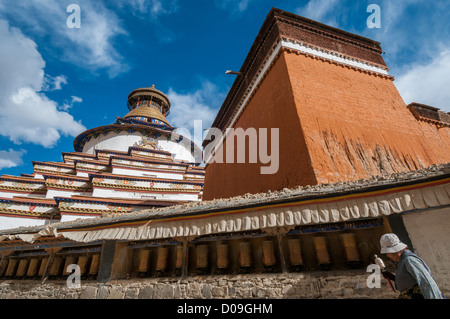 Pilger schwingt eigenen Gebetsmühlen, wie sie Kreise Pelkhor Chode Kloster Tempel, Gigatse, Tibet, China Stockfoto