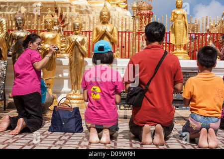 THAI FRAU FOTOGRAFIEREN IHRE FAMILIE BETEN VOR BUDDHASTATUEN IM WAT PHRA, DASS DOI SUTHEP TEMPEL CHIANG MAI THAILAND ASIEN Stockfoto