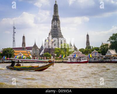 5. Oktober 2012 - Bangkok, Thailand - ein Longtailboot geht Wat Arun, der "Tempel der Morgenröte '' auf dem Chao Phraya River. Wat Arun ist eines der berühmtesten Tempel in Thailand. Der Khmer-Stil '' prang'' dominiert die Skyline dieses Teils von Bangkok. Long-Tail-Boote sind schmale Boote verwendet als Taxis auf den Wasserwegen von Thailand. Bangkok einmal Kreuz und quer durchzogen von Kanälen und Boote waren die Art, wie Menschen sich herumgesprochen. Jetzt wurden die meisten der Kanäle ausgefüllt und gepflastert. Der Chao Phraya-Fluss, der Bangkok teilt, hat immer noch regelmäßigen Passagierservice Boot. (Bild Kredit: Jack Kurtz/ZUMAPRESS.com ©) Stockfoto