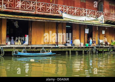 17. November 2012 - Bangkok, Thailand - traditionelle Gehäuse an einem Kanal im Abschnitt "Thonburi" von Bangkok. Bangkok war früher bekannt als das "Venedig des Ostens '' aufgrund der Anzahl der Wasserstraßen, die Kreuz und quer die Stadt gekreuzt. Nun die meisten der Wasserstraßen ausgefüllt aber Boote und Schiffe nach wie vor eine wichtige Rolle im täglichen Leben in Bangkok. Tausende von Menschen pendeln täglich auf dem Chao Phraya Express Boote und Schnellboote, die ply Khlong Saen Saeb oder Boote verwenden, um die Kanäle auf der Thonburi-Seite des Flusses zu erkunden. Boote werden verwendet, um die Rohstoffe durch die Stadt bis tief Wat zu schleppen Stockfoto