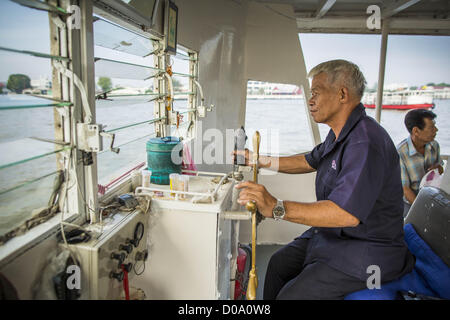 21. November 2012 - Bangkok, Thailand - A Fähre Kapitän steuert sein Boot über den Chao Phraya Fluss. Ein Netzwerk von Fähren verbinden Thonburi Abschnitt von korrektem Bangkok, Bangkok, überqueren den Fluss Chao Phraya. Der Fahrpreis beträgt 3 Thai Baht, ca. 0,15 $ (US). Die Boote sind der schnellste Weg, um von Norden nach Süden in Bangkok zu erhalten. Tausende von Menschen pendeln täglich auf dem Chao Phraya Express Boote und Schnellboote, die Khlong Saen Saeb verkehren. Boote werden verwendet, um die Rohstoffe durch die Stadt Tiefwasser-Häfen für den Export zu schleppen. (Bild Kredit: Jack Kurtz/ZUMAPRESS.com ©) Stockfoto