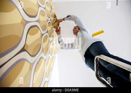 Junge Frau ist ihr Haus renovieren. Tapezieren, neue Tapete. Zum Selbermachen. Stockfoto