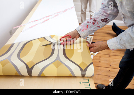 Junge Frau ist ihr Haus renovieren. Tapezieren, neue Tapete. Zum Selbermachen. Stockfoto