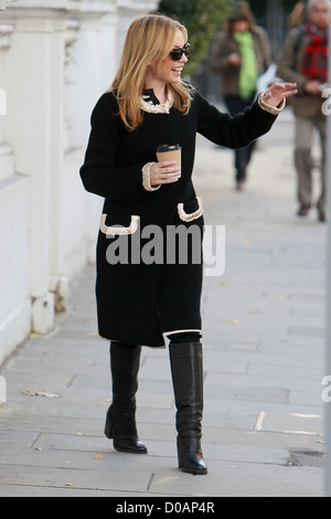 Kylie Migue ein Getränk halten, als sie ihr Haus verlässt. London, England Stockfoto