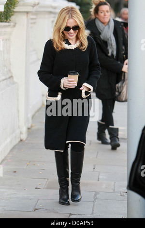 Kylie Minogue ein Getränk halten, als sie ihr Haus verlässt. London, England - 24.11.10 Stockfoto