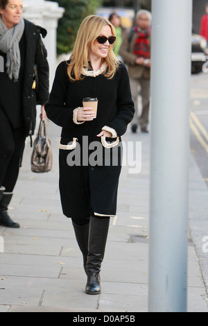 Kylie Minogue ein Getränk halten, als sie ihr Haus verlässt. London, England - 24.11.10 Stockfoto